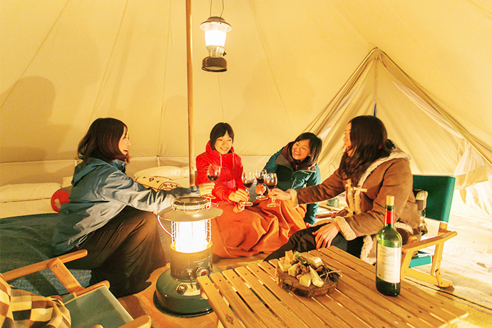 Imagine yourself with friends in broad space inside a tent with beds.